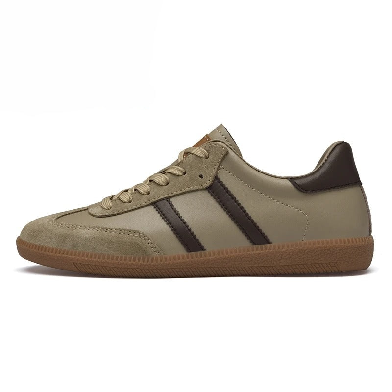 A low-top sneaker in taupe with dark brown leather side stripes, a dark brown heel tab, and a brown gum sole, shown in a side profile on a white background.